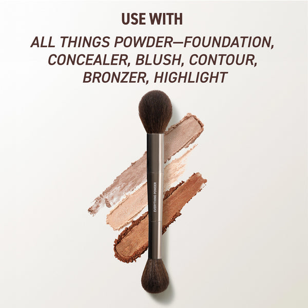 Everything powder brush with black bristles over foundation powder swatches