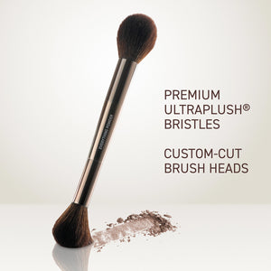 Powder brush angled view with dense black bristles and metallic rose-gold handle
