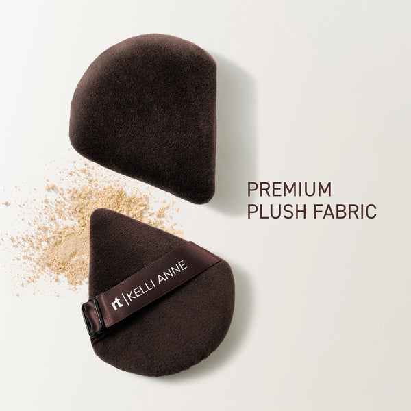 Two dark powder puffs with plush fabric and adjustable finger band